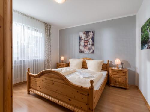 ein Schlafzimmer mit einem großen Holzbett und einem Fenster in der Unterkunft Ferienwohnanlage Oberaudorf E3 mit Hallenbad und Sauna in Oberaudorf