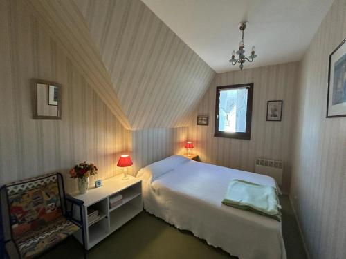 une chambre avec un lit, une table et une chaise dans l'établissement 2 Pièces secteur Thalasso et Mer, à Cabourg