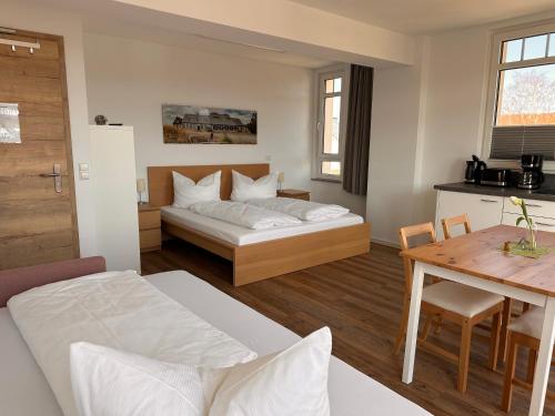 a bedroom with a bed and a table and a kitchen at Urlaubshaus-Erzgebirge in Zwönitz