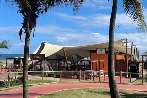 a tent at the beach with palm trees at New Studios by VLV Stays in Salvador