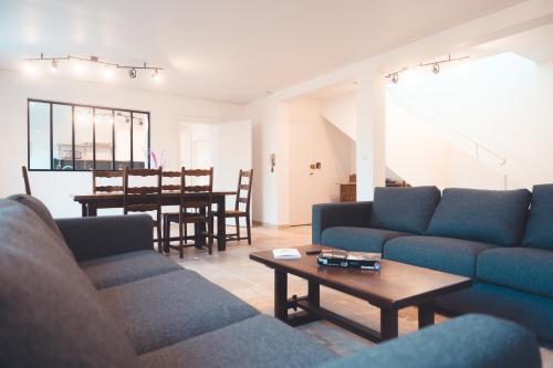 un salon avec des canapés bleus et une table dans l'établissement L'Unique- Maison de famille en Plein Centre-Ville, à Tours