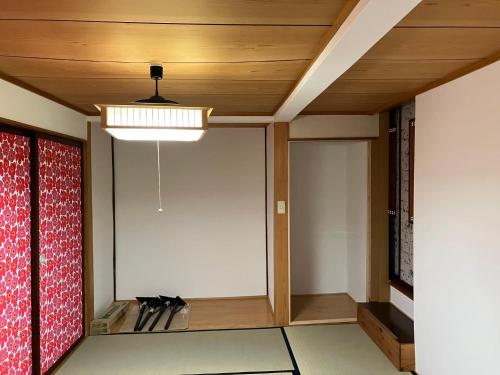 an empty room with a ceiling with a light at ゲストハウスわたうさぎ in Tsuruoka