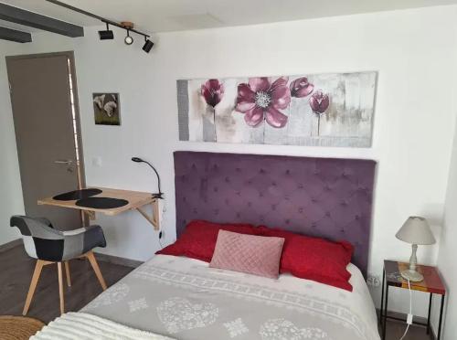 a bedroom with a bed with a purple headboard at Studio charmant à Valff avec jardin privé - 20 m² in Valff