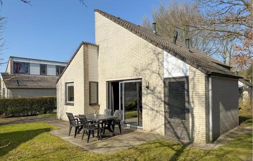 a house with a table and chairs on a patio at 3 Bedroom Stunning Home In Hoeven in Hoeven