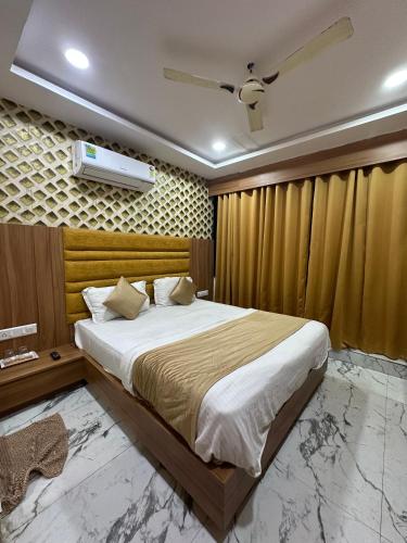 a bedroom with a large bed and a ceiling fan at Hotel Royal King in Ahmedabad