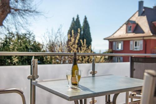 two glasses of wine on a table on a balcony at Gästehaus D i c k r e i t e r in Immenstaad am Bodensee