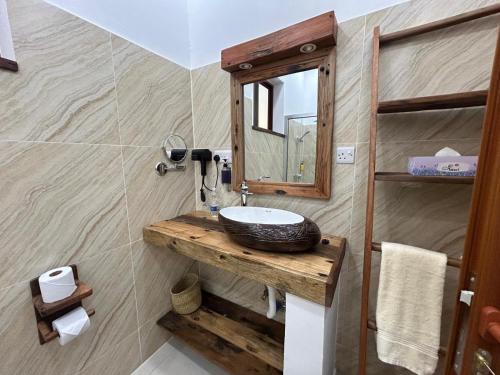 a bathroom with a sink and a mirror at M&M Villas Zanzibar in Kidoti