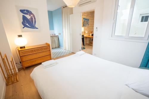 une chambre avec deux lits, une commode et un miroir dans l'établissement Purple T2 centre ville avec clim, à Montpellier