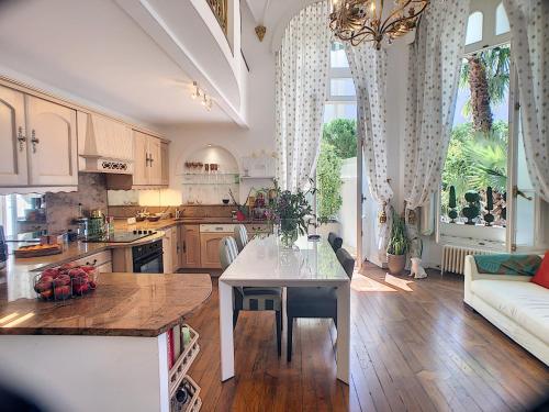 une cuisine avec une table et une grande fenêtre dans l'établissement Charmant appartement en duplex 288L, à Cannes