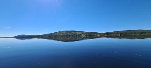 a large body of water with mountains in the background at Aurora Jukkas Riverside Lodge in Jukkasjärvi