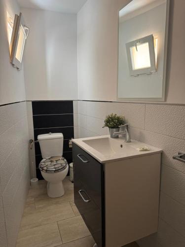 a bathroom with a toilet and a sink and a mirror at Apartamento IFAE 3 in Guía de Isora