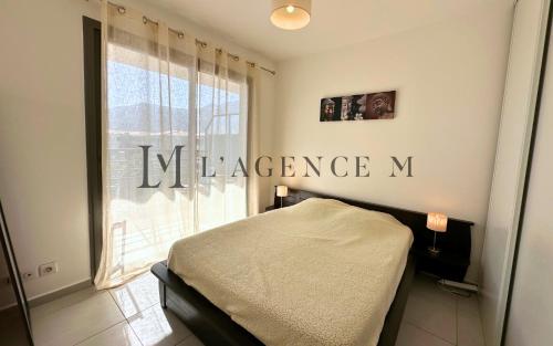 - une chambre dotée d'un lit et d'une fenêtre avec un signe dans l'établissement Appartement Le grand large Proche plage & ville, à Calvi