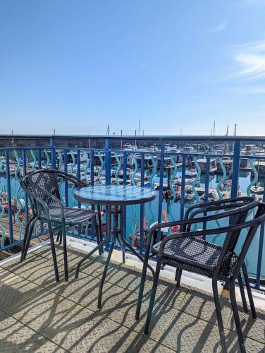 a table and chairs on a balcony overlooking a marina at Britannia Harbour View - Parking - by Brighton Holiday Lets in Brighton & Hove