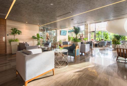 a lobby of a restaurant with chairs and tables at Queen Ann Nha Trang Hotel in Nha Trang