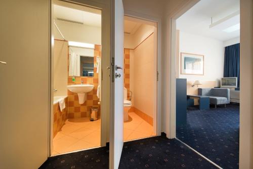 a room with a bathroom with a sink and a toilet at Hotel Grand Litava Beroun in Beroun