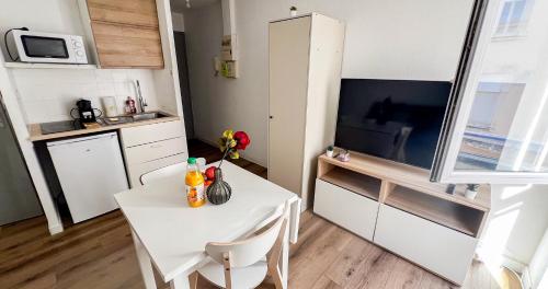 - une petite cuisine avec une table et des chaises blanches dans l'établissement Near Rempart - Wifi - Quiet and comfortable!, à Avignon