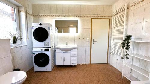 a bathroom with a sink and a washing machine at Geräumige Monteurunterkunft Plus in Lengerich