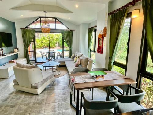 a living room with a couch and a table at Villa Coconut Khaolak in Khao Lak