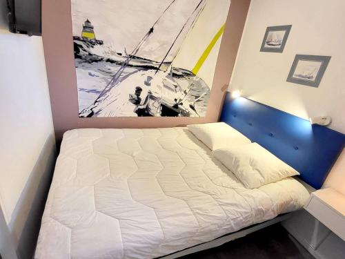 - un lit dans une chambre avec une photo sur le mur dans l'établissement T2 rénové avec piscine, parking privé et à 200m des plages - FR-1-316-274, à Six-Fours-les-Plages