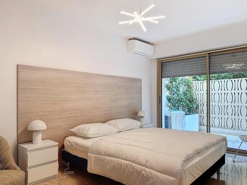 une chambre avec un lit et une grande fenêtre dans l'établissement A deux pas des plages piscine 346L FRANCHI, à Cannes
