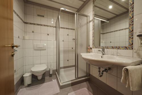 a bathroom with a toilet and a sink and a shower at Appartements Gladbach in Heiterwang
