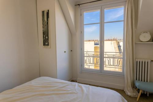 une chambre avec un lit et une fenêtre avec vue dans l'établissement Two rooms with view near canal, à Paris