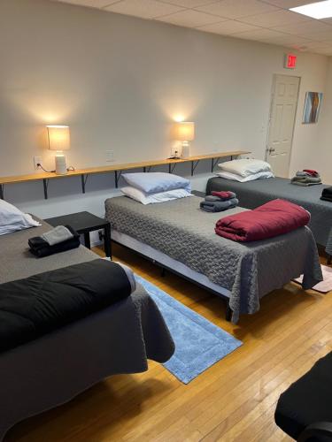 a room with three beds in a room at Art Gallery Hostel in Whitefield