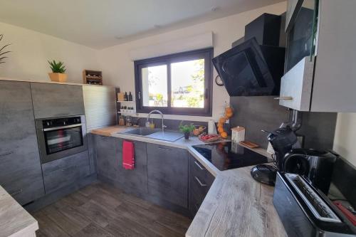 une petite cuisine avec un évier et une fenêtre dans l'établissement Nice House With Terrace Garden In Amfreville, à Amfréville