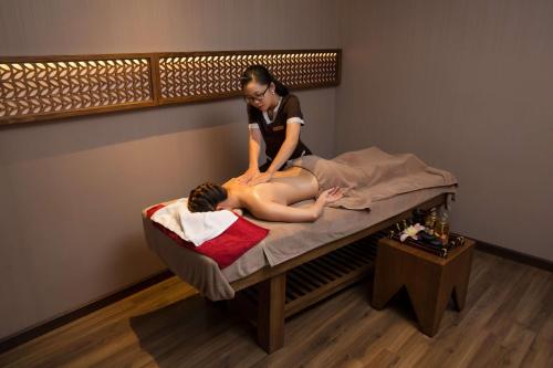 a woman giving a woman a massage on a bed at Queen Ann Nha Trang Hotel in Nha Trang
