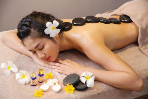 a woman laying in a bath tub with cosmetics at Queen Ann Nha Trang Hotel in Nha Trang