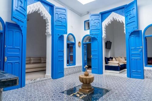 a room with blue doors and a vase in the middle at Ba Ali in Rabat