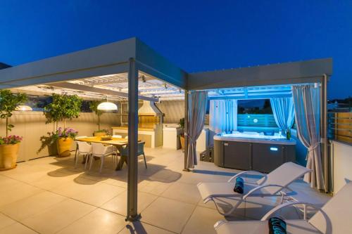a patio with a table and chairs and a kitchen at Ekaterini Luxury House in Lefkogeia