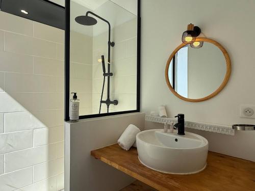 une salle de bain avec un lavabo et un miroir dans l'établissement Maison Piscine Jardin Parking, à Biarritz