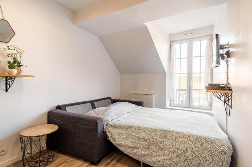 une chambre avec un lit dans une pièce blanche dans l'établissement Charmant appartement proche commodités et Disney !, à Montévrain