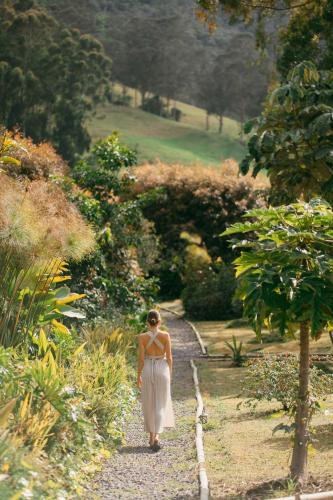 a woman in a white dress walking down a path at Glamping Lumbre in Salento