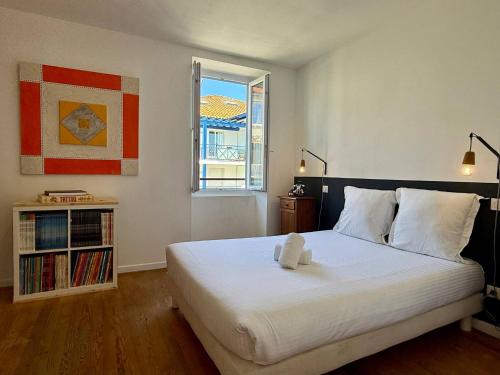 une chambre avec un grand lit blanc avec une fenêtre dans l'établissement Maison Piscine Jardin Parking, à Biarritz