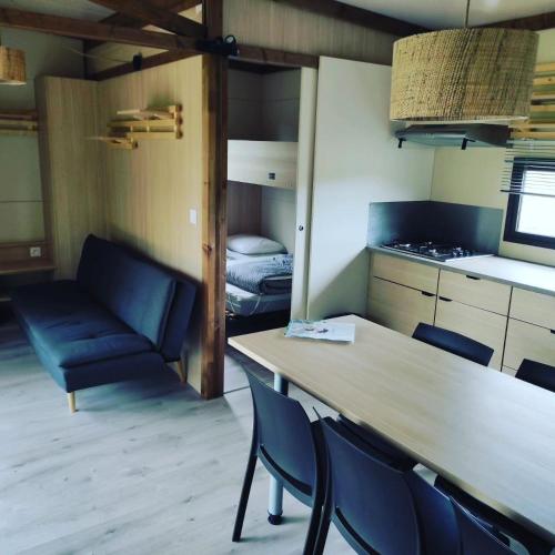 une pièce avec une table, des chaises et un lit dans l'établissement Chalet au bord de l'eau, à Maulévrier