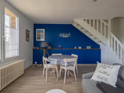 un salon avec une table et un mur bleu dans l'établissement Ti Ma Zud Bihan, à Pleumeur-Bodou