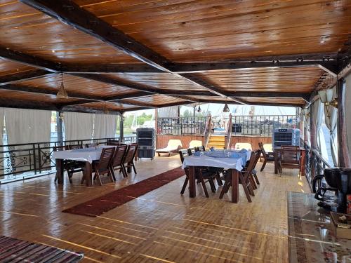 a dining room with tables and chairs on a balcony at Saphir Dahabiya luxury sailing boat Nile cruise Every Saturday from Luxor 4 or 7 nights in Luxor