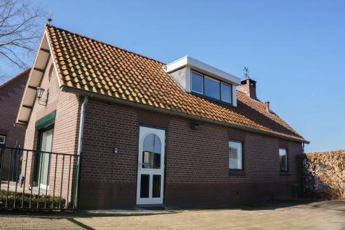 a red brick house with a white door and window at De Locht in Sint Michielsgestel