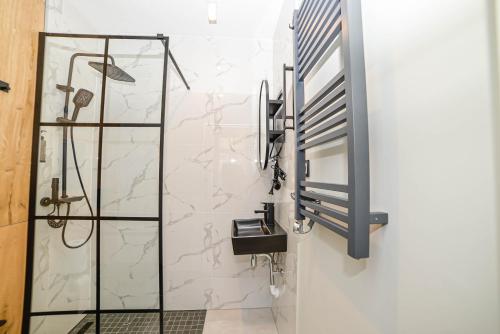 a bathroom with a glass shower stall and a sink at Homly Nook in Rīga