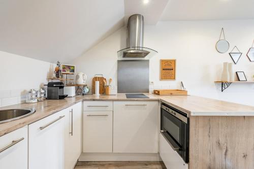 une cuisine avec des armoires blanches et un évier dans l'établissement Charmant appartement proche commodités et Disney !, à Montévrain