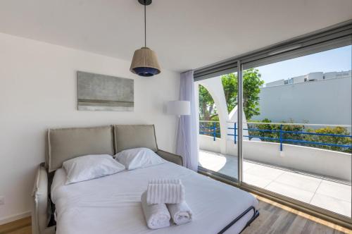 a bedroom with a bed and a large window at MY Hôtel Résidences - La Grande-Motte in La Grande Motte