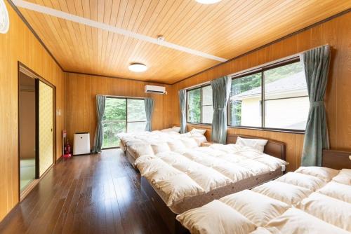 a row of beds in a room with wooden walls at Green Oasis Cottage B in Hakone