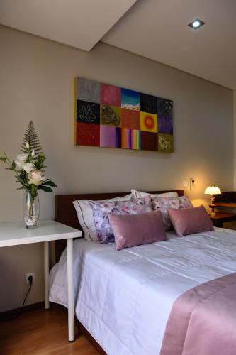 a bedroom with a bed with a vase of flowers on it at Hotel Alendouro in Macedo de Cavaleiros