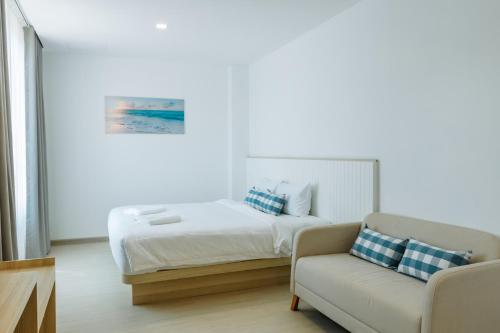 a white bedroom with a bed and a couch at Sea Side at Ao Nang Landmark Night Market Krabi in Ban Khlong Haeng
