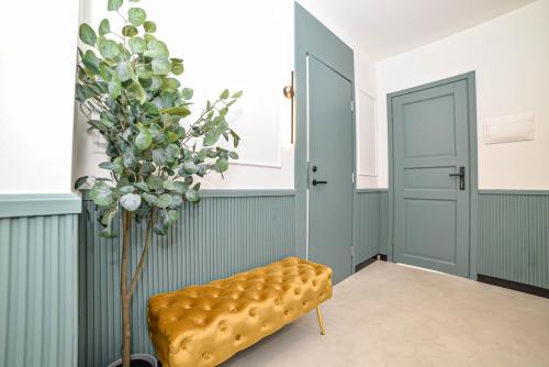 a room with a yellow bench and a plant at Homly Nook in Rīga