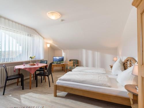 a bedroom with two beds and a table and a desk at Ferienwohnanlage-Oberaudorf 1 Zimmer App E 8 mit Hallenbad und Sauna in Oberaudorf