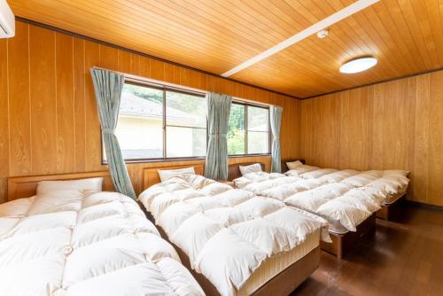 a row of beds in a room with a window at Green Oasis Cottage B in Hakone