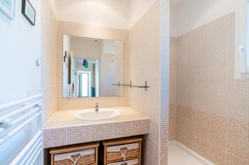une salle de bain avec un lavabo et un miroir dans l'établissement Villa avec Piscine sur le Golf, à Béziers